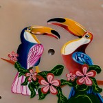 Deux toucans stylisés, peints en micro-peinture sur une nacre rose.